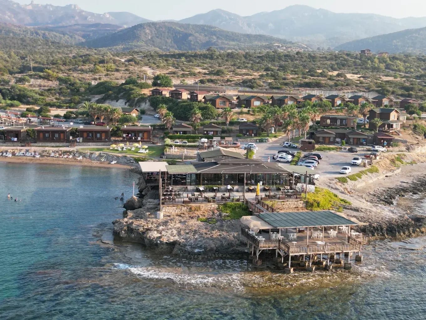 Kayalık burun üzerindeki teraslı sahil restoranı ve bungalovlar
