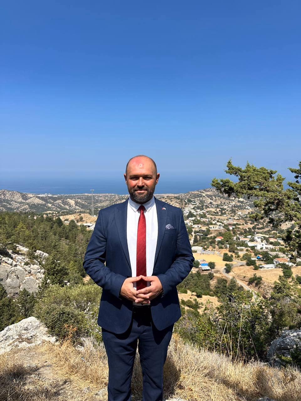 Doç. Dr. Muharrem Özdemir, yüksekten Tatlısu yerleşimi ve deniz ufku önünde